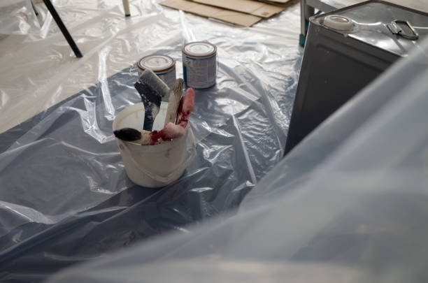 The women are painting paint on the walls of the house looking happily. DIY. Do It Yourself.