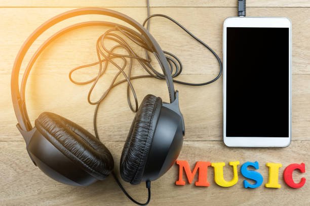 istock headphones and smartphone on wooden background 975587478