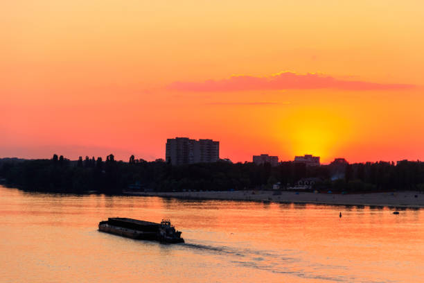 istock Tugboat pushing a heavy long barge on the river Dnieper at sunset 975589802