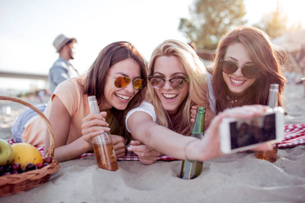 istock Three young smilling female friends take selfie 975592956