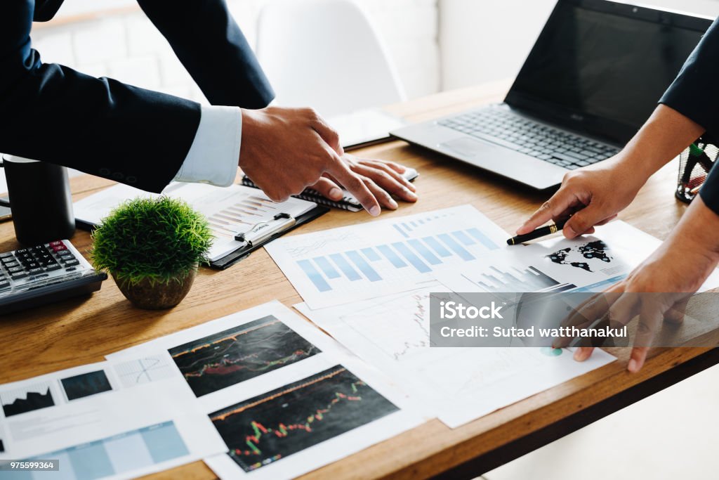 Group of Businesspeople discussing the charts and graphs,businessmen discussing on stockmarket document in office,Business partners consult documents at meeting,Concept of brainstorm teamwork planning Business Stock Photo
