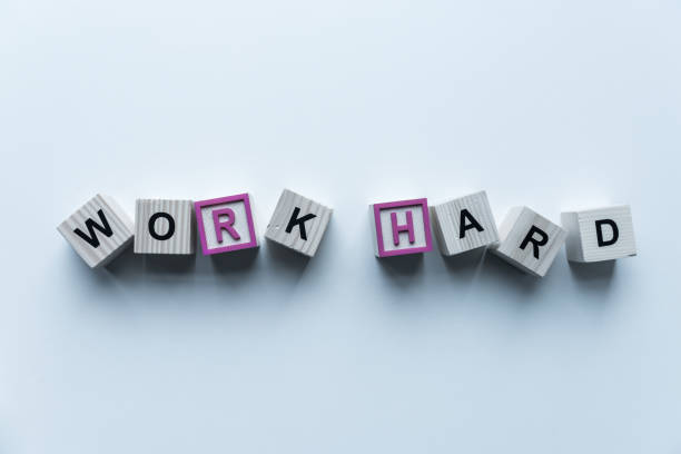 istock top view of wooden cubes with words Work Hard on blue surface 975602516