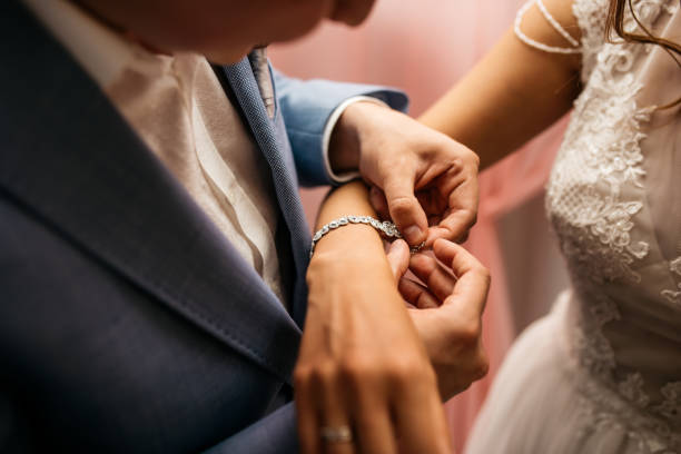the groom fastens the bracelet on the bride's wrist - passion women human hand macro imagens e fotografias de stock