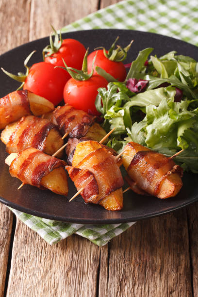 istock Grilled potato slices with bacon and fresh salad close-up. vertical 975605460