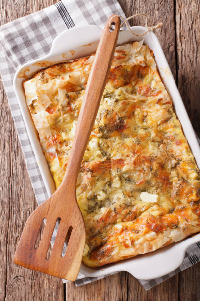 istock Balkan food: Serbian pie Gibanica with cheese, eggs and greens close-up. Vertical top view 975605882