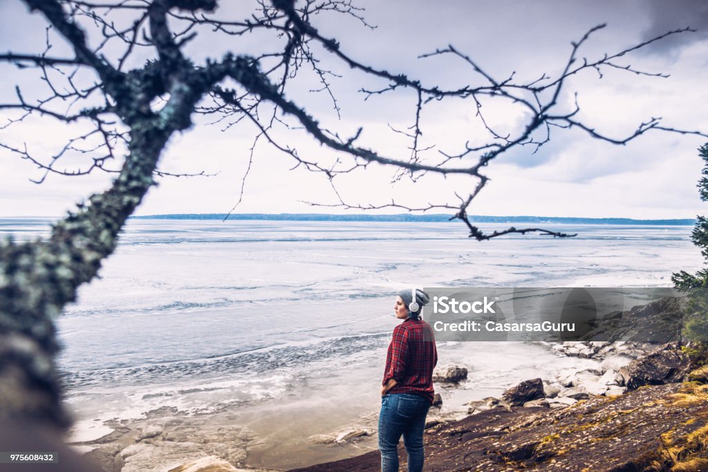 Young Woman Enjoying, Relaxing and Observing the view of Lake Finland Stock Photo