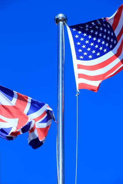 istock Union Jack  &  American Flag  in the Wind 975608548