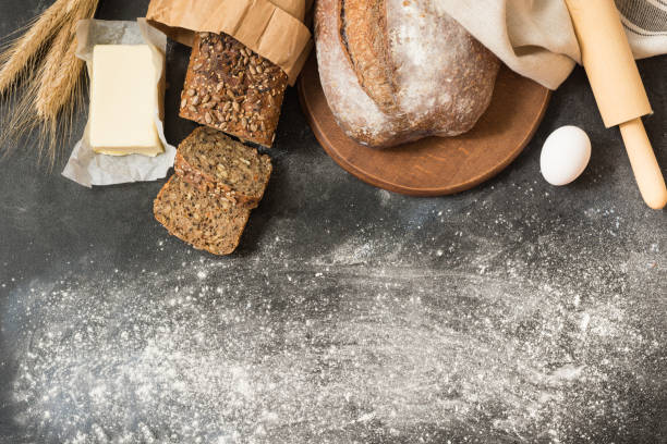 istock Various homemade rye bread and wheat on black stone table. Ingredients for cooking bread. Top view with space for your text. 975608812