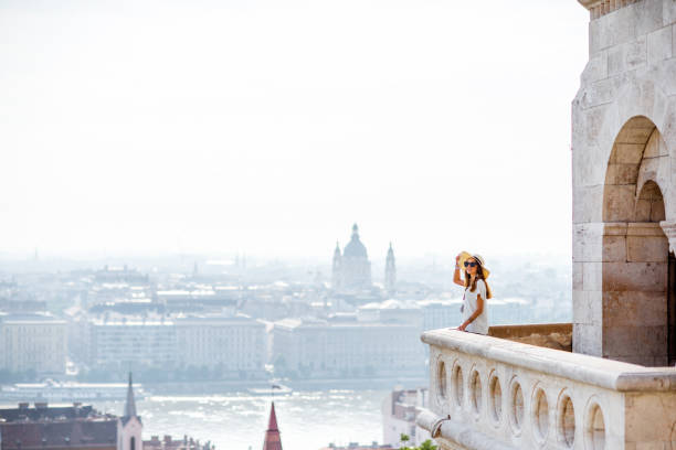 View on the wall of Fiserman's bastion with woman standing on the terrace enjoying great view on Budapest city in Hungary