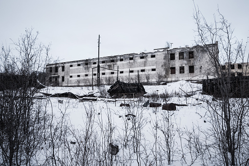 Exterior of old decayed abandoned prison in Kolyma in evening light