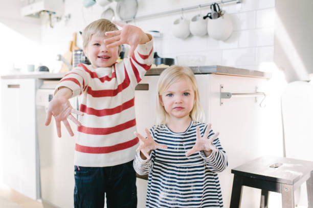 istock Happy children baking sweet buns at home 975615838