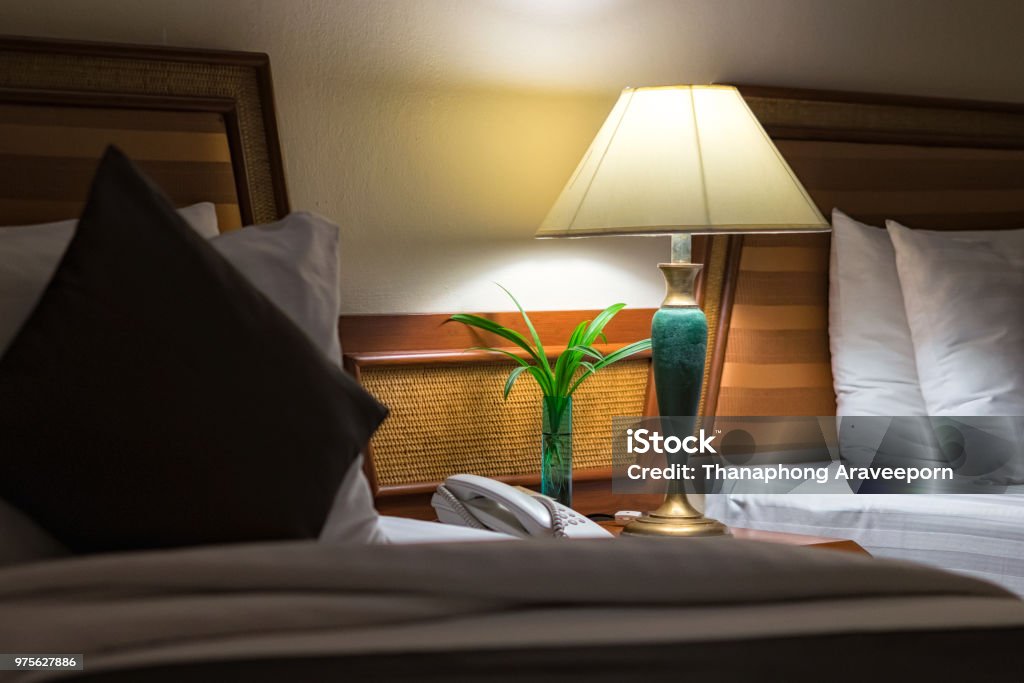 Bed and nightstand in modern bedroom and equipment for a comfortable and restful experience. Night Stock Photo