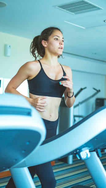 mulher usando uma máquina de exercícios na academia de ginástica - 6184 - fotografias e filmes do acervo