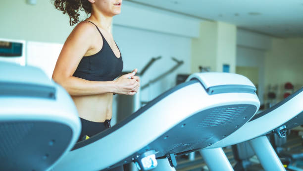 istock Young woman jogging in gym 975632990