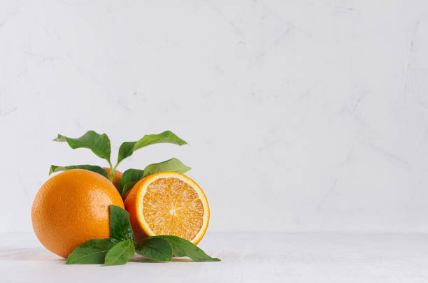 istock Bright group oranges with fresh green leaf and piece on soft light white modern interior. 975637508