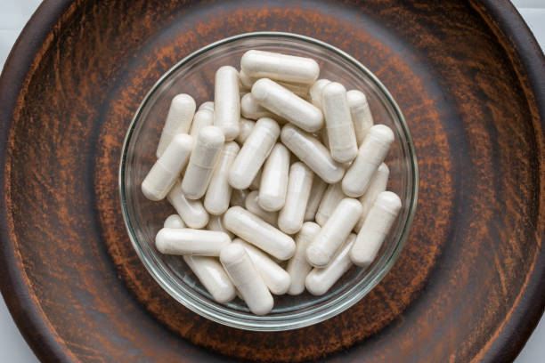istock Kava Kava Extract root Veg Capsules on round clay brown plate. Herbal Supplements with calming Relaxation, effect, helps support emotional balance 975646978