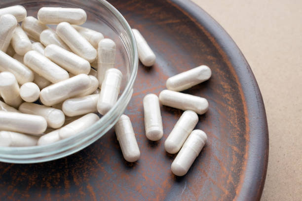 istock Kava Kava Extract root Veg Capsules on round clay brown plate. Herbal Supplements with calming Relaxation, effect, helps support emotional balance 975647156