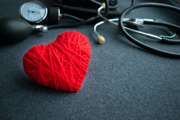 빨간색 스레드 tonometer 회색 테이블에 함께 심장입니다.  혈압, 의사가 직장 혈압 모니터입니다. 의료 장비입니다. 심장 진단 - thread gauge 뉴스 사진 이미지