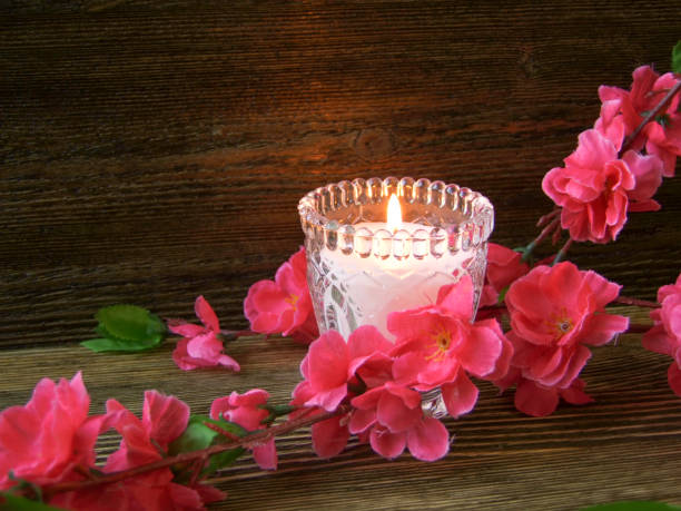 istock Sakura and candle on a wooden background 975648194