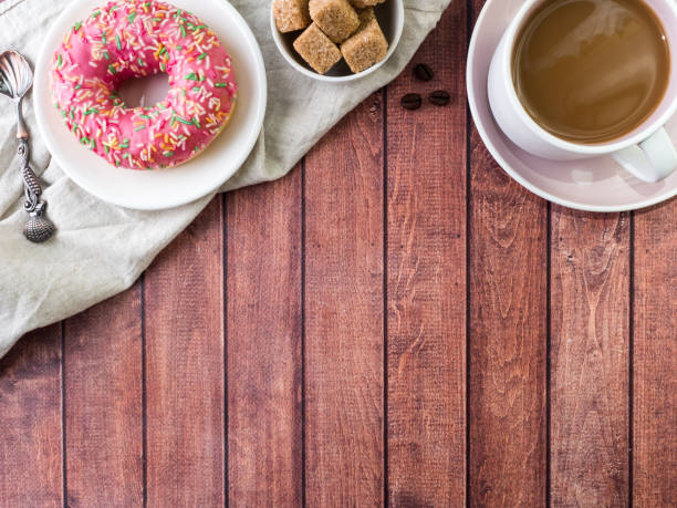 istock Donuts and coffee on wooden table. Top view with copy space 975648270