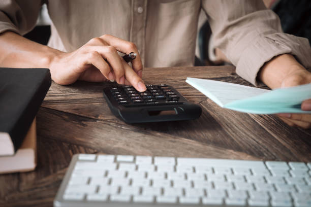 mujer de negocios asiática utilizando una calculadora para calcular los números de cerca. concepto de contabilidad y finanzas negocios - subtraction fotografías e imágenes de stock