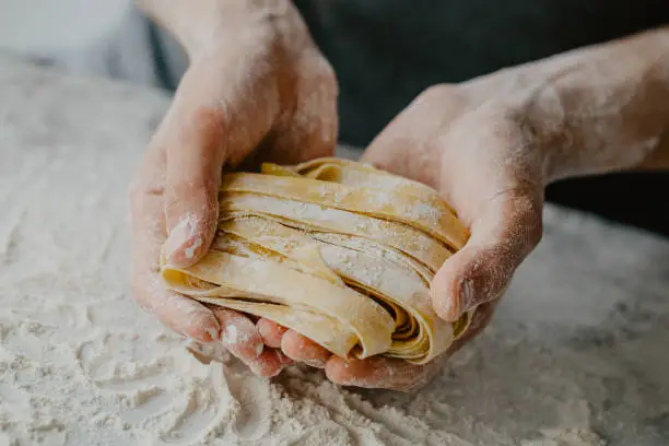 Closeup of process of making cooking homemade pasta. Chef make fresh italian traditional pasta