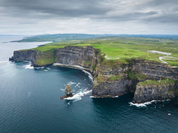 Cliffs of Moher Ireland Aerial Wild Atlantic Way Areal view towards the famous Cliffs of Moher under a rainy and dramatic skyscape in summer. Burren Region, County Clare, Ireland doolin photos stock pictures, royalty-free photos & images