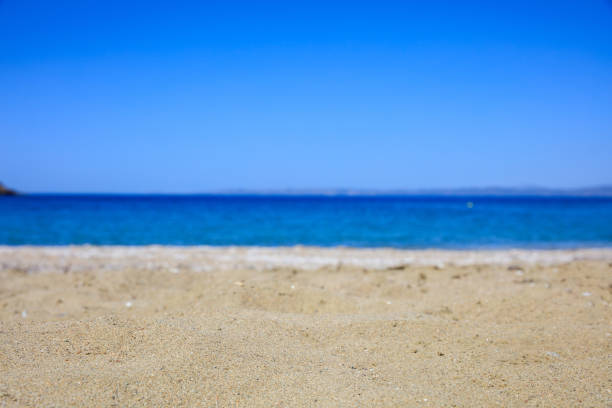 Sandy beach on blue sky and sea background