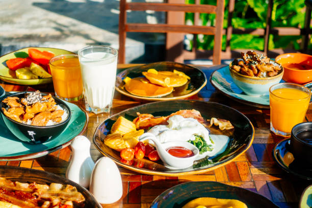 istock Healthy breakfast set with egg bacon pancakes orange juice milk bread and coffee 975669956