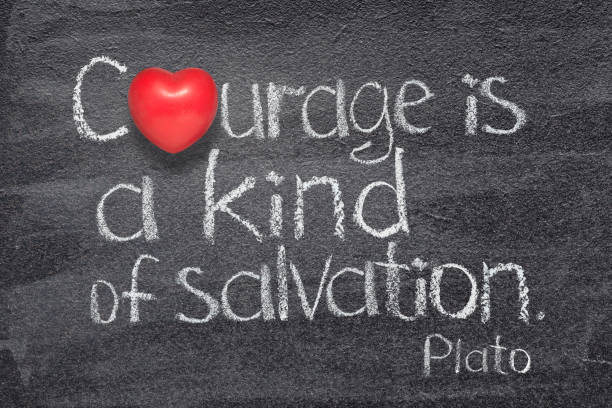Courage is a kind of salvation quote of ancient Greek philosopher Plato written on chalkboard with red heart symbol instead of O