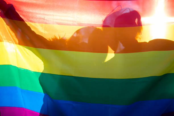 Happy lesbian couple holding rainbow flag stock photo