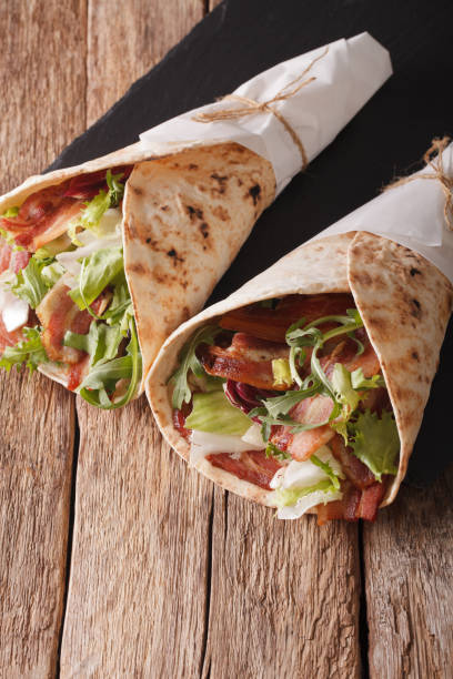istock Bacon and lettuce wrapped in pita bread close-up. vertical 975692376