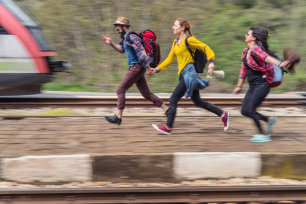 istock Travelers getting late for the train and running on the railway platform 975695188