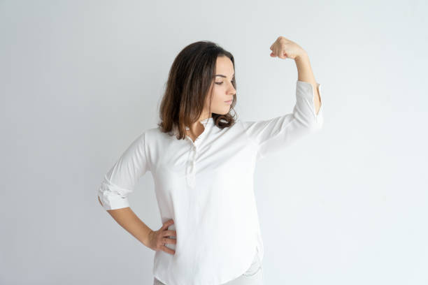 istock Serious proud girl showing strength gesture 975699090