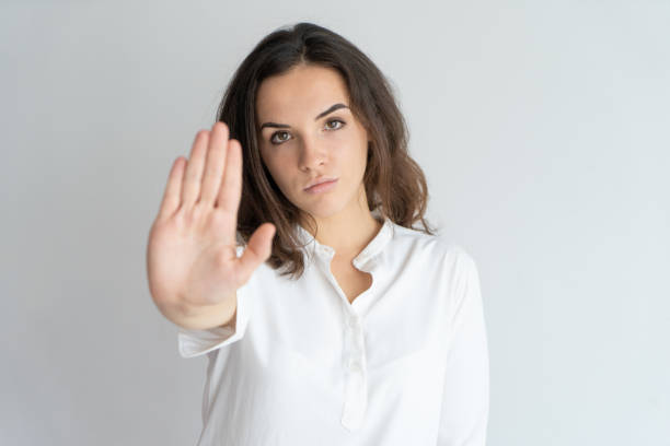 istock Serious determined girl showing stop sign 975699096