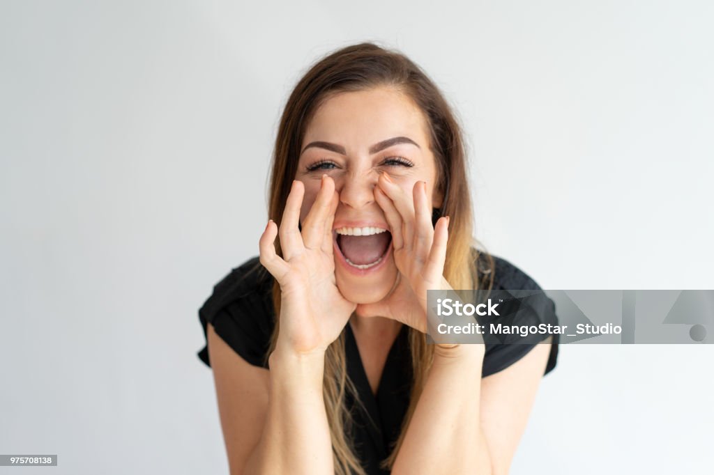 Happy excited lady screaming loud, sharing great news Happy excited lady screaming loud, sharing great news. Cheerful young Caucasian woman with hands at face shouting of joy. Good news concept Shouting Stock Photo
