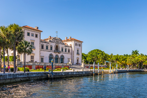 MIAMI, USA - AUG 24, 2014: Miami Vizcaya museum at waterfront under blue sky on Biscayne Bay in the Coconut Grove neighborhood of Miami, Florida.