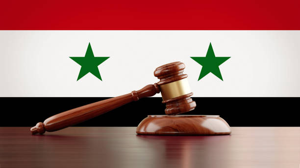 istock Wooden Gavel In Front Of Syrian Flag 975724018