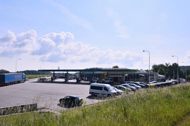 азс под названием omv с припаркованными автомобилями и камуфляжами солнечным утром возле шоссе d1, ведущего из праги в город брно - omv стоковые фото и изображения