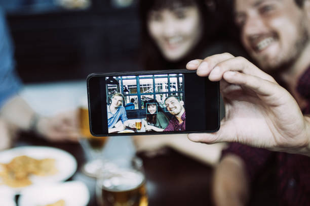 istock Three Friends Taking Selfie Photo in Pub 975725470