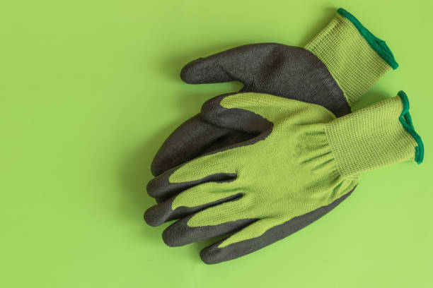 Rubber gloves for garden working on pastel color background top view.