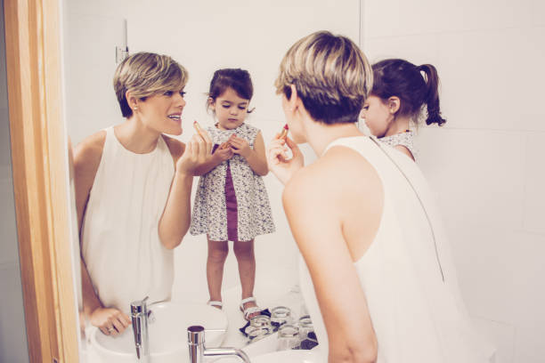istock Curious daughter trying to use lipstick 975743084