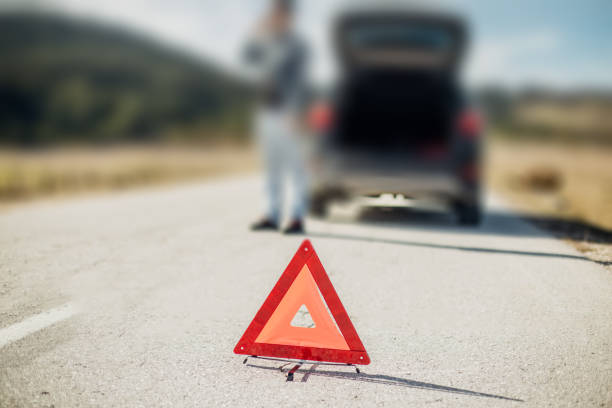 istock Broken car behind the warning triangle on the street 975750160
