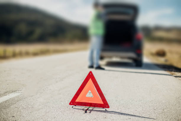 istock Warning triangle in front of the broken down vehicle on the highway 975750194