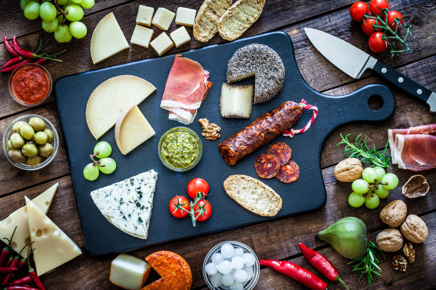 istock Cheese and cold meat board shot from above on wooden table 975756496