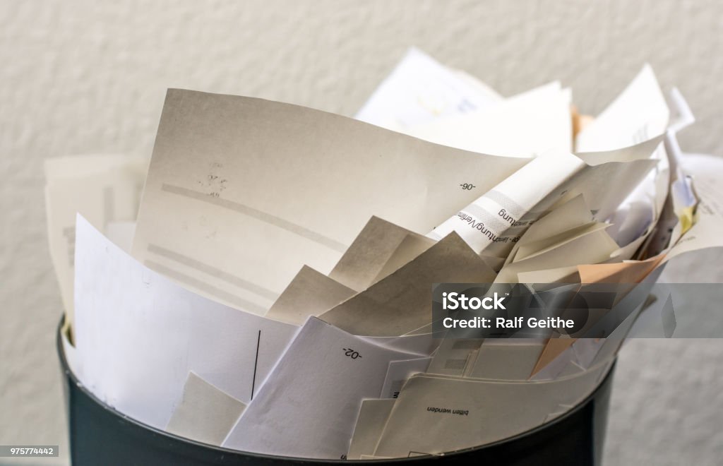 Overfilled recycle bin with paper Overcrowded trash in an office Paper Stock Photo