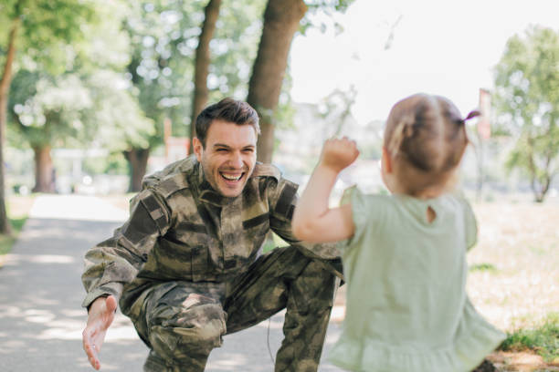 mała dziewczynka biegnąca w kierunku żołnierza - armed forces family military child zdjęcia i obrazy z banku zdjęć