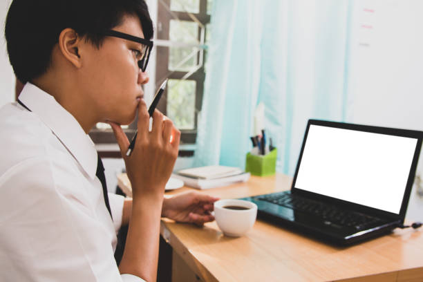 istock Blur Business man sitting using laptop with blank screen on desk in office at home 975777018