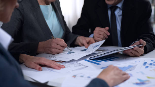 istock Government officials discussing import and export report diagrams, research 975778318