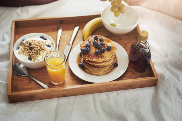 High angle shot of an unrecognizable man enjoying breakfast in bed at home